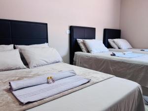 a room with two beds with towels on them at WS Hotel in Campo Alegre