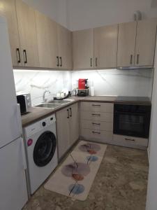 a kitchen with a sink and a washing machine at Loutraki Cozy Loft in Loutraki