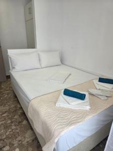 a large white bed with towels on top of it at Loutraki Cozy Loft in Loutraki