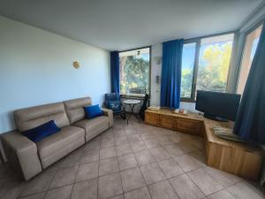 a living room with a couch and a flat screen tv at Sunset Garden Sanremo in Sanremo