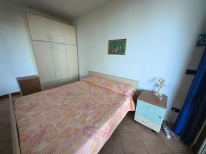 a small bedroom with a bed and a night stand at Sunset Garden Sanremo in Sanremo
