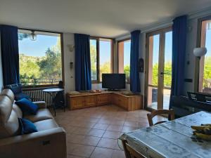 a living room with a couch and a television at Sunset Garden Sanremo in Sanremo