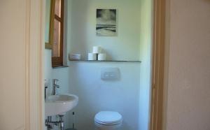 a bathroom with a white toilet and a sink at The Art House in Kotrónion