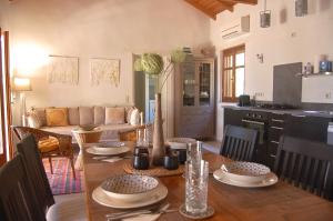 a kitchen and living room with a wooden table and a dining room at The Art House in Kotrónion