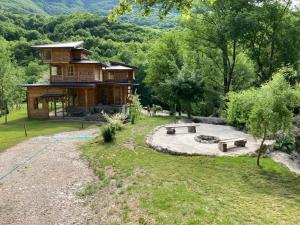 a log house with benches in front of it at Tara Rafting Resort in Foča