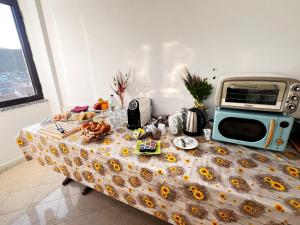 a table with a microwave on top of it at Ostello Brebei Niedda - Base Camp Outdoor & View in Gonnesa +81 photos