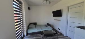 a small bedroom with a small bed and a tv at Quiet Apartment in Oświęcim