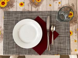a white plate on a table with a fork and knife at Ostello Brebei Niedda - Base Camp Outdoor & View in Gonnesa