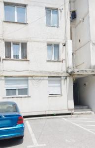a blue car parked in front of a building at Maria Central Studio in Târgu Neamț