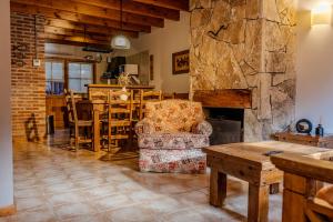 a living room with a chair and a stone fireplace at Apart Hotel Agua Escondida in San Martín de los Andes