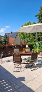 a table and chairs under an umbrella on a patio at Ferienwohnung zum Albuch in Nördlingen