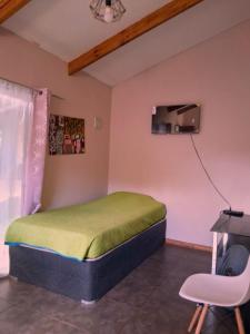a bedroom with a bed and a desk and a chair at Kauaraki Henua Iti in Hanga Roa