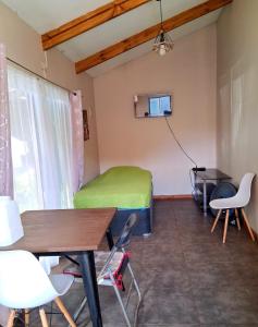 a room with a bed and a table and chairs at Kauaraki Henua Iti in Hanga Roa