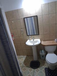 a bathroom with a sink and a toilet and a mirror at Kauaraki Henua Iti in Hanga Roa