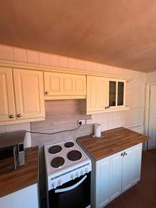 a kitchen with white cabinets and a stove top oven at Goody Suites in Newcastle upon Tyne +14 photos