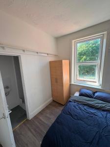 a small bedroom with a bed and a window at Goody Suites in Newcastle upon Tyne