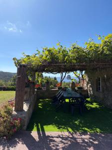 a garden with a table and chairs under a pergola at Casa Pereiro playa de Esteiro in Viveiro