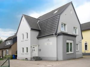 a white house with a black roof at Die kleine Pension in Delmenhorst