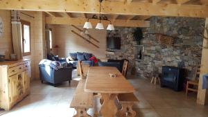 a living room with a wooden table and a stone wall at Can PUGAT in Bolquere Pyrenees 2000