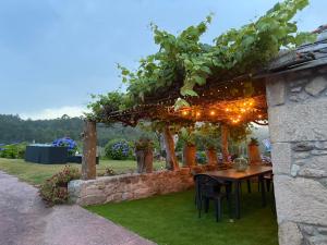 a pergola with a table and chairs in a yard at Casa Pereiro playa de Esteiro in Viveiro
