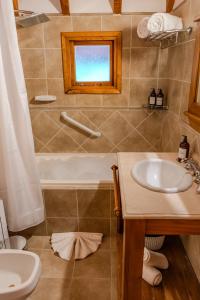 a bathroom with a sink and a bath tub at Apart Hotel Agua Escondida in San Martín de los Andes +25 photos