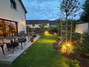 a backyard with a table and chairs and a tree at La Villa M77 in Boitron