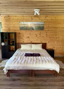 a bedroom with a large bed in a wooden wall at Vizbuļi, Amatciems in Amatciems