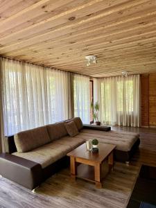 a living room with a large couch and a table at Vizbuļi, Amatciems in Amatciems