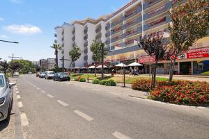 a street with cars parked on the side of a building at T2 Tivoli in Vilamoura