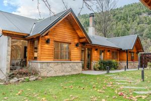 a log home with a gambrel roof at Apart Hotel Agua Escondida in San Martín de los Andes