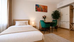 a bedroom with a bed and a table with chairs at Clementine Apartman by Flats4You in Százhalombatta