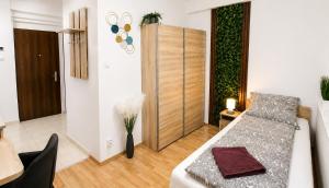 a room with a bed and a table and a door at Clementine Apartman by Flats4You in Százhalombatta