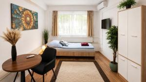 a small room with a bed and a table at Clementine Apartman by Flats4You in Százhalombatta +31 photos