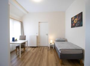 a bedroom with a bed and a desk and a table at Die kleine Pension in Delmenhorst