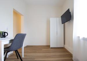 a room with a desk and a chair and a tv at Die kleine Pension in Delmenhorst