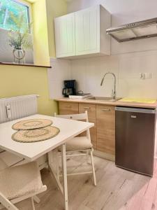 a kitchen with a table and chairs and a sink at Apartament Zielony Gaj Ustroń Wczasowa 90 in Ustroń