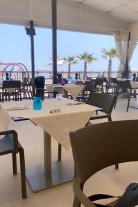 an empty restaurant with tables and chairs and the ocean at Sottomarina Bungalows Spiaggia in Sottomarina