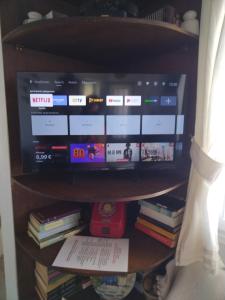a book shelf with a tv and some books at ECO Balcony to the Aegean in Stení