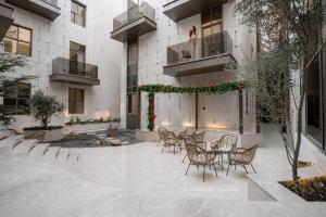 a courtyard of a building with chairs and a table at Liora Al Yasmin District in Riyadh