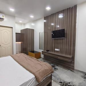 a bedroom with a bed and a flat screen tv at Yash Residency Lodging And Boarding in Ulhāsnagar