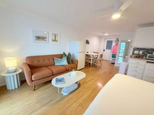 a living room with a couch and a table at Surfside - Boutique Studio Condo with Pool in Hampton