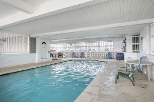 a large swimming pool with a table and chairs at Surfside - Boutique Studio Condo with Pool in Hampton