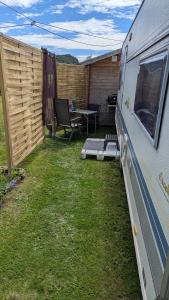 an rv parked in a yard next to a fence at Mikael's Bed & Spa - Camping Suite in Sandefjord