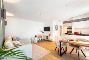 a living room and kitchen with a table and chairs at Nomes Apartment in Axams +3 photos