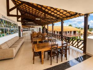 a restaurant with wooden tables and chairs and a couch at Pousada Escarpas in Capitólio