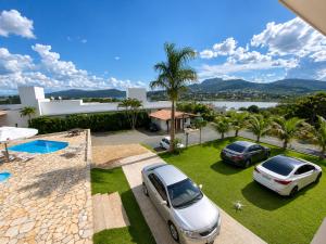two cars parked on a lawn in front of a house at Pousada Escarpas in Capitólio