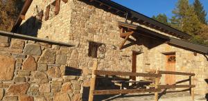 a stone building with a bench in front of it at Can PUGAT in Bolquere Pyrenees 2000
