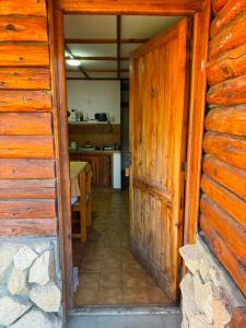 an open door to a kitchen in a log cabin at Complejo Villa Azul in Esquel