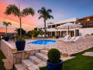 a villa with a swimming pool and a resort at Pousada Escarpas in Capitólio