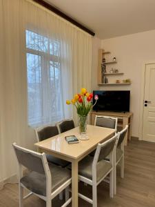 a dining room table with chairs and a vase of flowers at Narek B&B in Goris